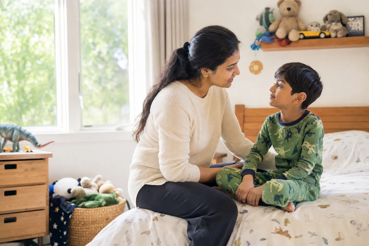 A mother talking gently with her son on the edge of his bed