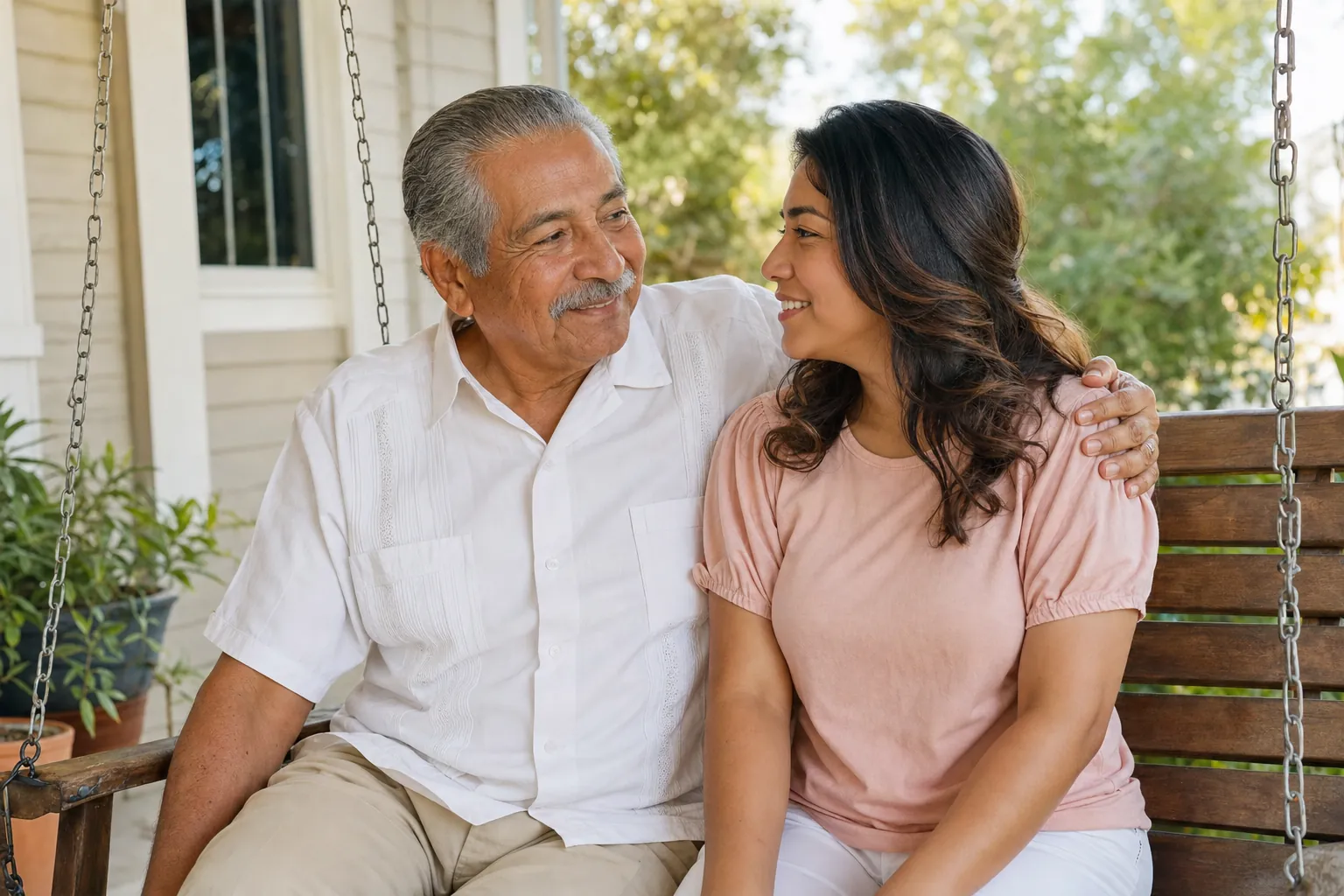 A grandfather sitting beside his granddaughter on a porch swing