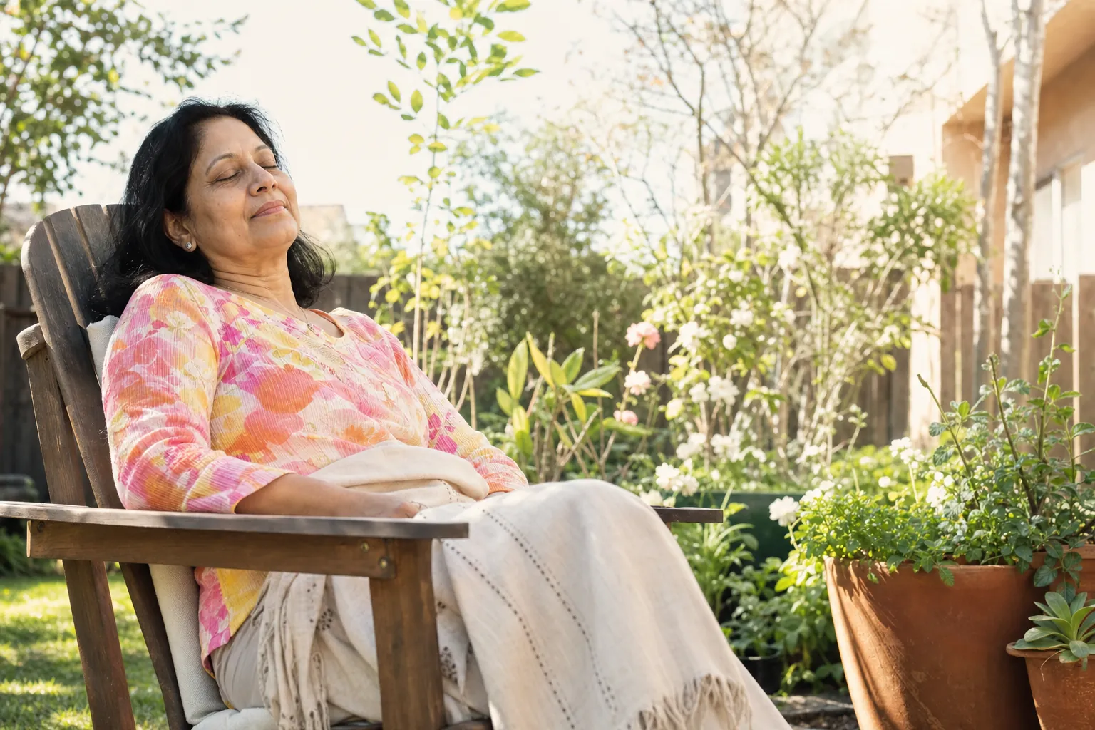 A woman resting with eyes closed in a sunlit garden chair